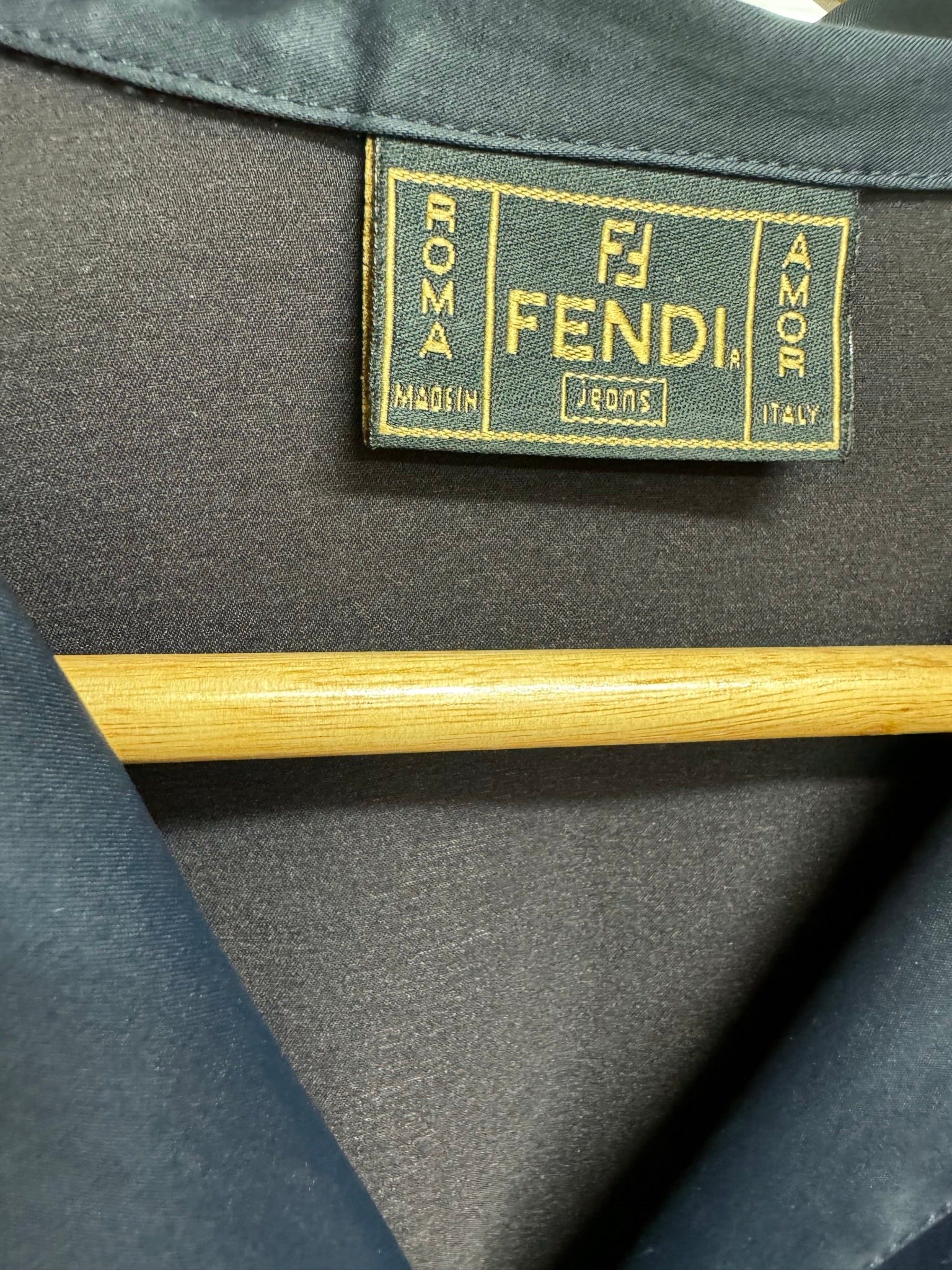 Close-up of Vintage Fendi Black shirt label showing "Fendi Jeans" and "Made in Italy" on silk-like material.